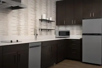 a kitchen with brown cabinets and a white refrigerator at Residence Inn by Marriott Kenwood Cincinnati in Kenwood