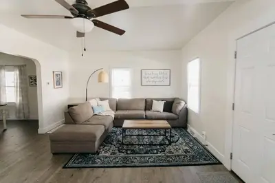 a living room with a couch and a ceiling fan at Beautiful Cape Cod House in Central Location in Dayton