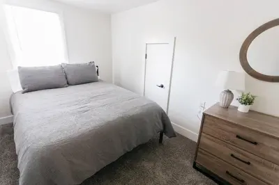 a bedroom with a bed and a mirror and a dresser at Beautiful Cape Cod House in Central Location in Dayton