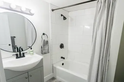 a white bathroom with a sink and a shower at Beautiful Cape Cod House in Central Location in Dayton