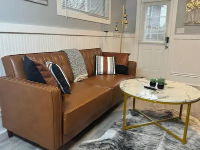 a brown couch in a living room with a table at Little house on 47th in Cleveland