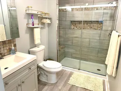 a bathroom with a toilet and a glass shower at Little house on 47th in Cleveland