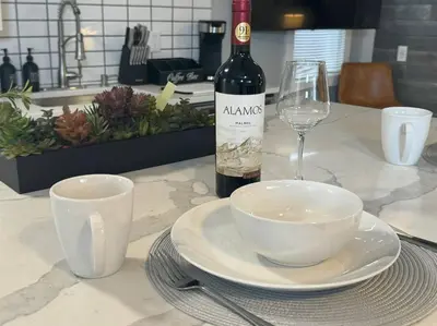 a bottle of wine and a plate and a wine glass at Little house on 47th in Cleveland
