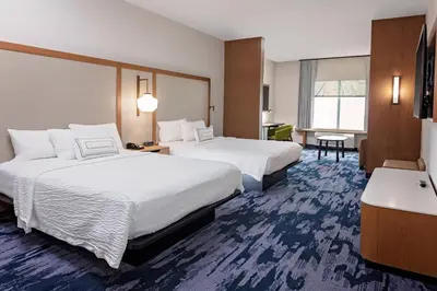 a hotel room with two beds and a desk at Fairfield by Marriott Port Clinton Waterfront in Port Clinton