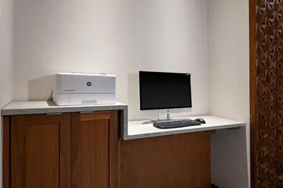 a desk with a computer and a monitor and keyboard at Fairfield by Marriott Port Clinton Waterfront in Port Clinton