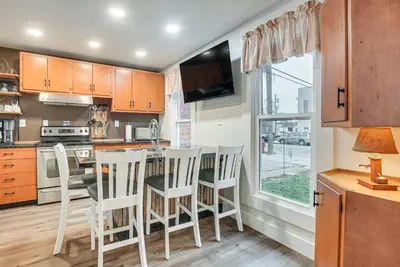 a kitchen with wooden cabinets and a table and chairs at West Liberty Vacation Rental Near Mad River! in West Liberty