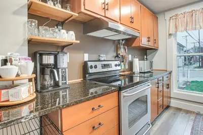 a kitchen with wooden cabinets and a stove top oven at West Liberty Vacation Rental Near Mad River! in West Liberty
