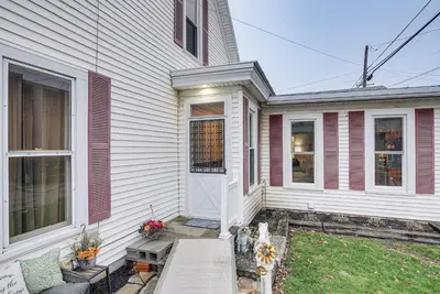 a white house with a porch and a door at West Liberty Vacation Rental Near Mad River! in West Liberty