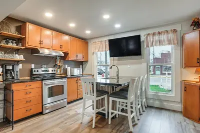 a kitchen with wooden cabinets and a table with chairs at West Liberty Vacation Rental Near Mad River! in West Liberty