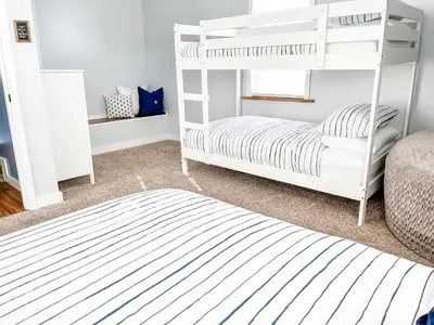 a bedroom with two bunk beds and a bed at Anchors Away - Relaxing Cottage Minutes from Lake in Buckeye Lake