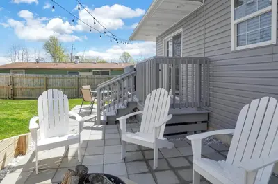 a group of white chairs sitting on a porch at Anchors Away - Relaxing Cottage Minutes from Lake in Buckeye Lake