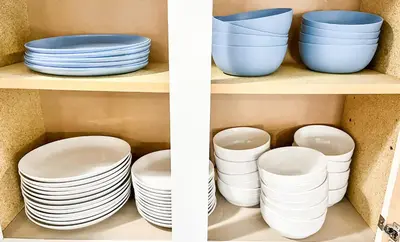 two photos of plates and bowls on a shelf at Anchors Away - Relaxing Cottage Minutes from Lake in Buckeye Lake