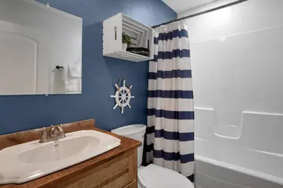 a bathroom with a sink and a toilet and a shower at Anchors Away - Relaxing Cottage Minutes from Lake in Buckeye Lake