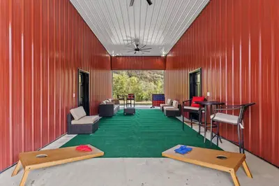a red building with a green floor with furniture on it at New Barndo/Private River Access/ 2 Private Hot Tub in Stanton