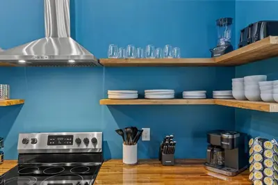 a kitchen with blue walls and a stove at New Barndo/Private River Access/ 2 Private Hot Tub in Stanton