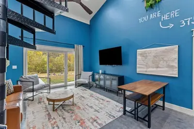 a living room with a blue wall at New Barndo/Private River Access/ 2 Private Hot Tub in Stanton