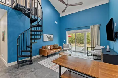 a blue living room with a spiral staircase at New Barndo/Private River Access/ 2 Private Hot Tub in Stanton