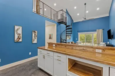 a blue room with a fireplace and a staircase at New Barndo/Private River Access/ 2 Private Hot Tub in Stanton