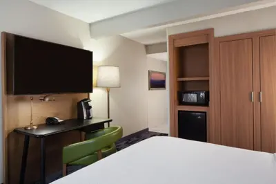 a hotel room with a bed and a desk and a television at Fairfield Inn & Suites by Marriott Charleston in Charleston