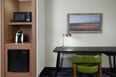 a room with a desk and a microwave and a television at Fairfield Inn & Suites by Marriott Charleston in Charleston