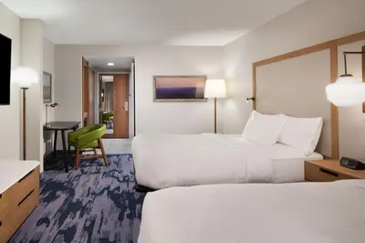 a hotel room with two beds and a desk at Fairfield Inn & Suites by Marriott Charleston in Charleston