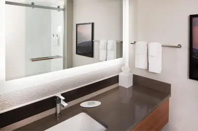 a bathroom with a sink and a large mirror at Fairfield Inn & Suites by Marriott Charleston in Charleston