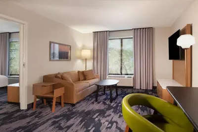 a living room with a couch and a table at Fairfield Inn & Suites by Marriott Charleston in Charleston