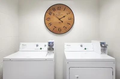 a clock on a wall next to two machines at Fairfield Inn & Suites by Marriott Charleston in Charleston