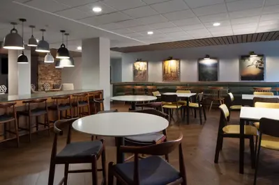 a restaurant with tables and chairs and a bar at Fairfield Inn & Suites by Marriott Charleston in Charleston