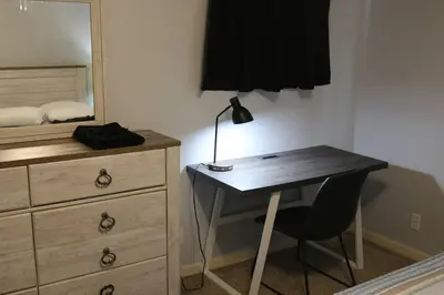 a bedroom with a dresser and a desk with a lamp at Athens city townhouse, 3 bedroom, 2.5 baths, Wi-Fi in Athens
