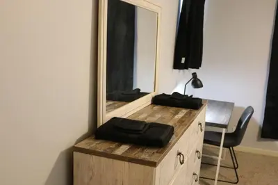 a mirror on top of a wooden dresser with a chair at Athens city townhouse, 3 bedroom, 2.5 baths, Wi-Fi in Athens