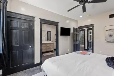 a bedroom with a bed and a ceiling fan at New Barndo/Kayak Launch/ 2 Private Hot Tubs in Stanton