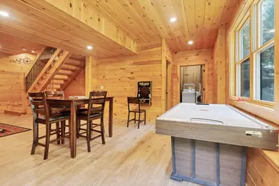 a kitchen and dining room with a pool table in a log cabin at Peek A Boo Cabins: Cozy Cabin in Logan