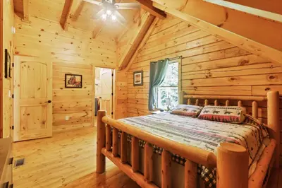 a bedroom with a bed in a log cabin at Peek A Boo Cabins: Cozy Cabin in Logan