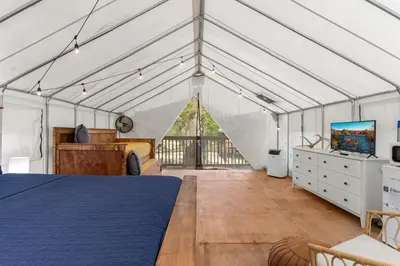 a bedroom in a tent with a bed and a tv at Red River Elusive Elk Glamping Tent 1 in Stanton