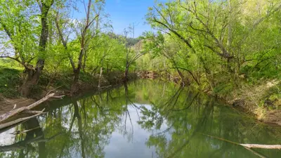 a river with trees reflecting in the water at Red River Elusive Elk Glamping Tent 1 in Stanton