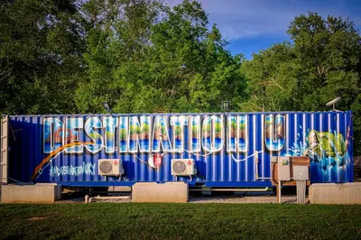 a blue container with graffiti on it in a park at Red River Elusive Elk Glamping Tent 1 in Stanton