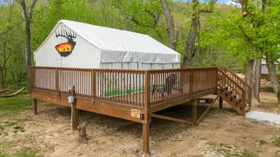 a yurt with a wooden deck in the woods at Red River Elusive Elk Glamping Tent 1 in Stanton