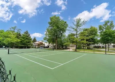 a tennis court with trees in the background at Quiet 2-Bedroom Condo with Garage and Fast Wi-Fi in Fort Wayne