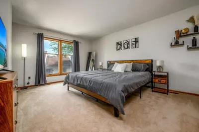 a bedroom with a large bed and a window at Quiet 2-Bedroom Condo with Garage and Fast Wi-Fi in Fort Wayne