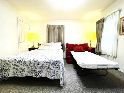 a bedroom with a bed and a red couch at Bittersweet Inn in Paulding