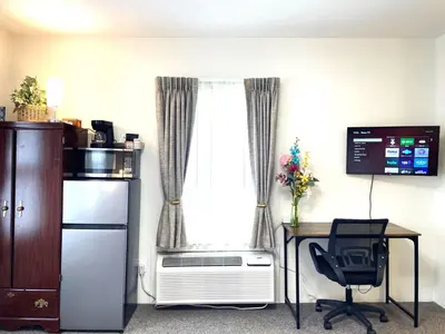 a room with a desk and a window with a heater at Bittersweet Inn in Paulding