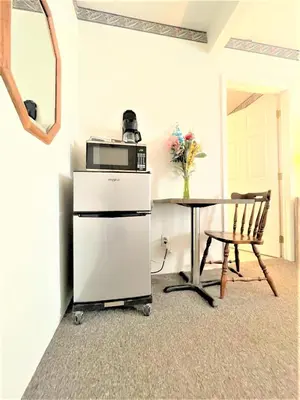 a kitchen with a table and a microwave on top of a refrigerator at Bittersweet Inn in Paulding