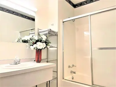 a bathroom with a sink and a shower with a vase of flowers at Bittersweet Inn in Paulding