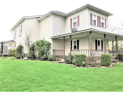 a white house with a lawn in front of it at Bittersweet Inn in Paulding