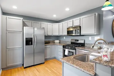 a kitchen with stainless steel appliances and white cabinets at Lakefront, Private Covered Dock, Huge Balconies in Williamstown