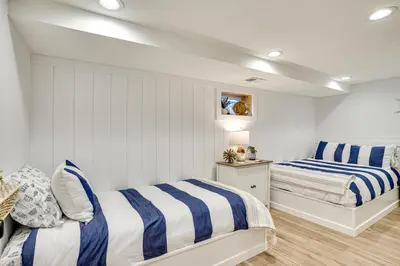 two beds in a room with white and blue stripes at Montpelier Lake House with Deck, Dock and Fireplace! in Montpelier