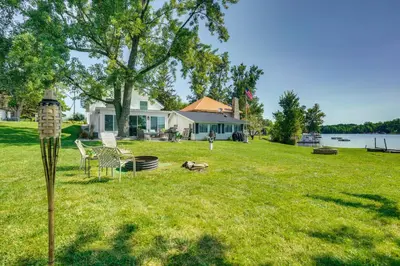 a house on a lawn with a bird feeder at Montpelier Lake House with Deck, Dock and Fireplace! in Montpelier