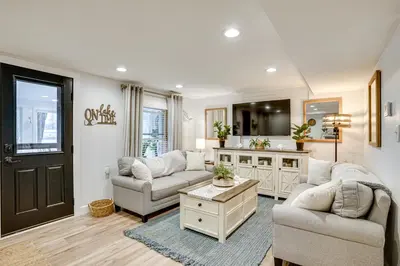 a living room with two couches and a table at Montpelier Lake House with Deck, Dock and Fireplace! in Montpelier