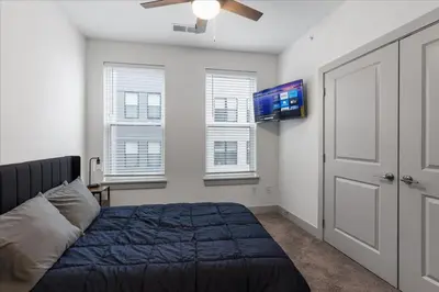a bedroom with a bed and a flat screen tv at Charming 1BR 1BA Apartment Near Downtown Cincinnati in Cincinnati